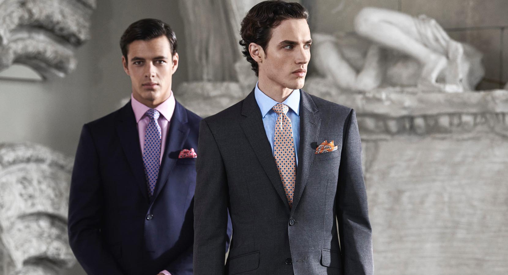 Two men wearing formal suits, shirts and ties